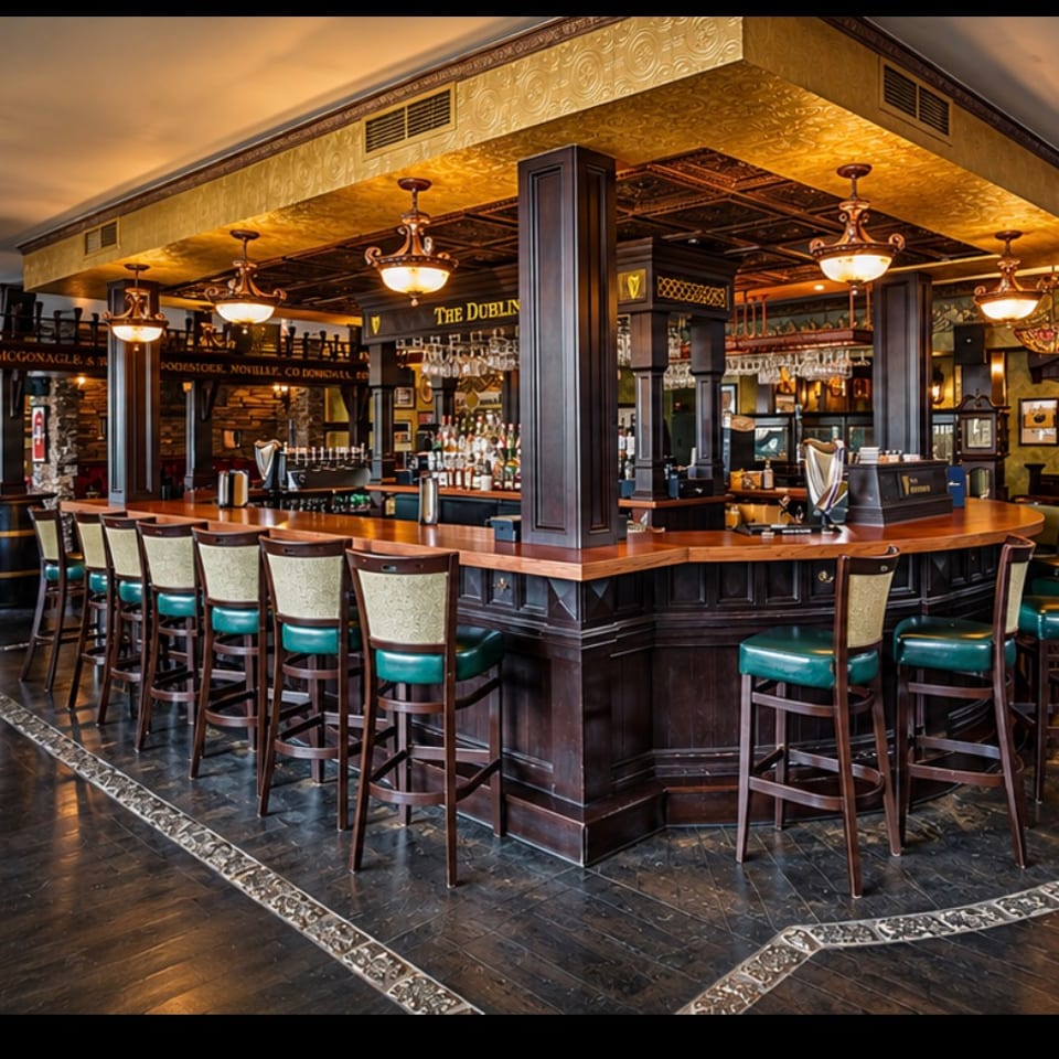 The Dubliner's wooden bar with green bar stools, ornate gold ceiling and pendant lights.