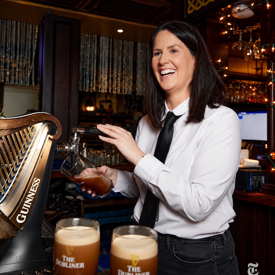 Bartender pouring Guinness at The Dubliner, with two pints on the bar.